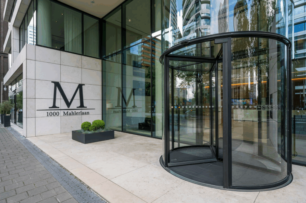 Entrance of the modern office building at 1000 Mahlerlaan with a glass revolving door.